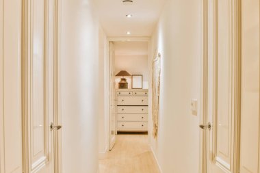 Geniş, parlak bir koridorun içi beyaz tonlarda.