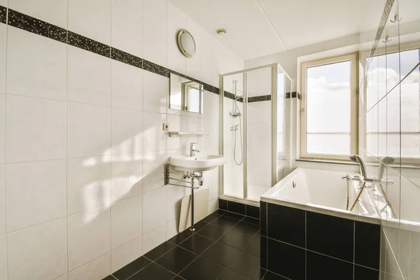 Bathroom interior finished with ceramic black and white tiles — Zdjęcie stockowe