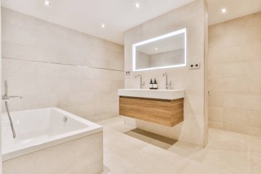 Banyo içinde seramik lavabo ve küvet var.