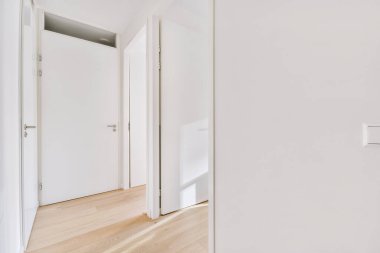 A small white corridor leading to different rooms