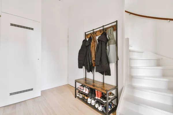 Un pasillo con una escalera de caracol y una percha de ropa — Foto de Stock