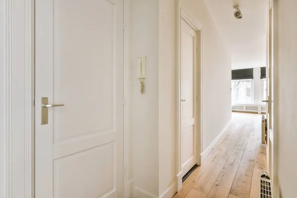 A spacious straight corridor with several doors on the sides — ストック写真