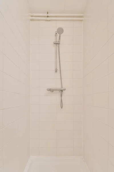 View of the bathroom with shower surrounded by white tiles — Fotografia de Stock