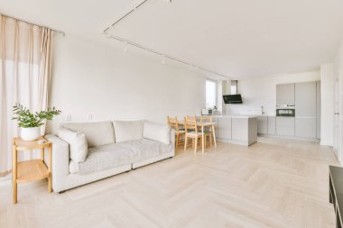 Modern mutfağın köşesinde beyaz duvarlar, masa, aşçı vs.