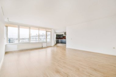 Mutfağa giden yolu ve geniş penceresi olan boş salon.