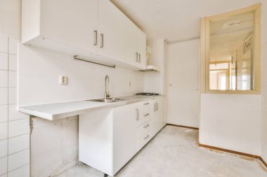 Modern bir evin dairesine erişimi olan beyaz tonlu eski moda bir mutfak.