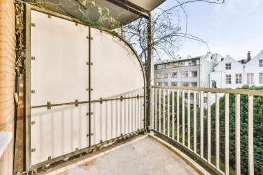 Sokak doğasına bakan sıcacık bir evde metal parmaklıklı balkon.