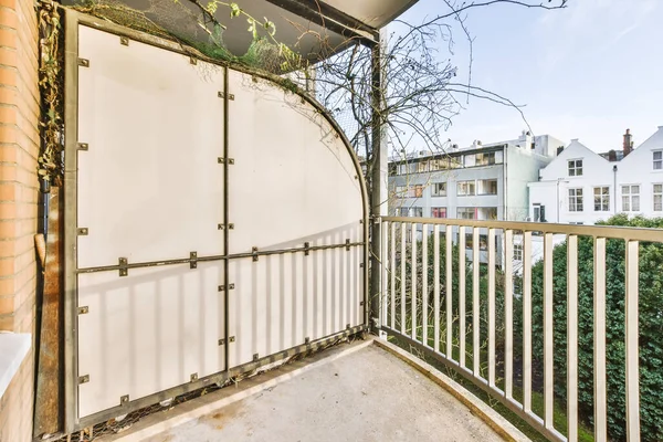 Sokak doğasına bakan sıcacık bir evde metal parmaklıklı balkon.