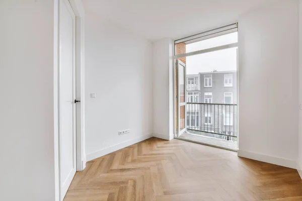 Empty white room with door leading to balcony — Stockfoto