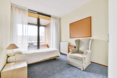 Beyaz dizaynlı halı zeminli geniş bir yatak odası.