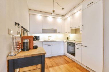 Beyaz dolapları olan rahat, minimalist bir mutfak.