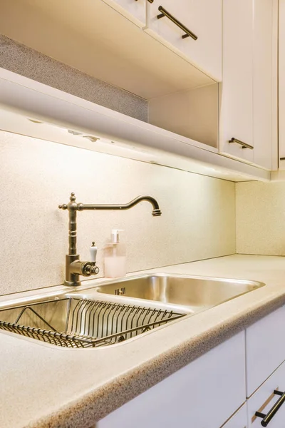 Beyaz dolapları olan rahat, minimalist bir mutfak.