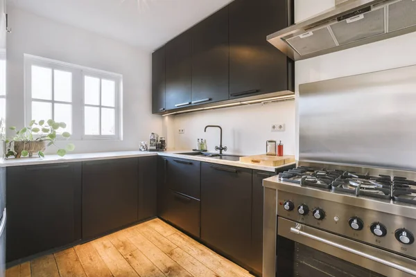 Siyah dolaplı köşe mutfağı. — Stok fotoğraf
