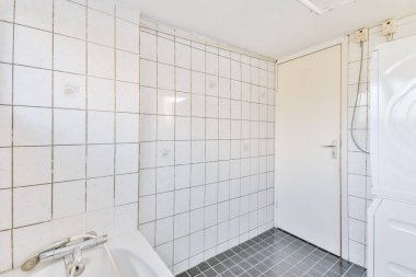 Çamaşır odasıyla birleşmiş küçük bir banyo.
