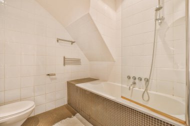 Küvette duş kabini olan geniş bej bir banyo.