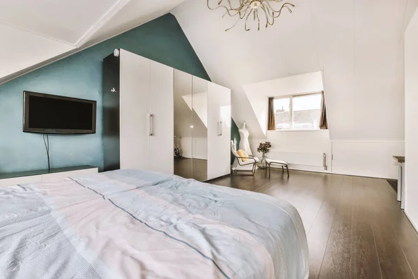 Light mansard bedroom with wardrobe and tv — 스톡 사진