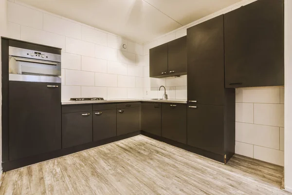 A spacious room with a corner kitchen in black colors — Stock Photo, Image