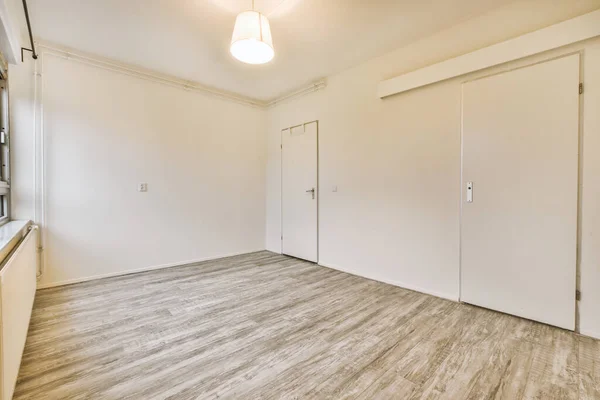 A spacious bright empty room with laminate floors — Stockfoto