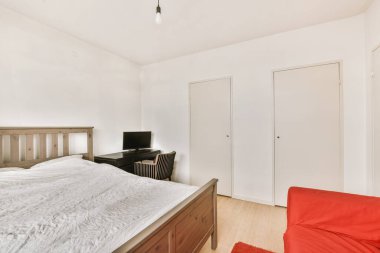 Ahşap gardıroplu aydınlık yatak odası.