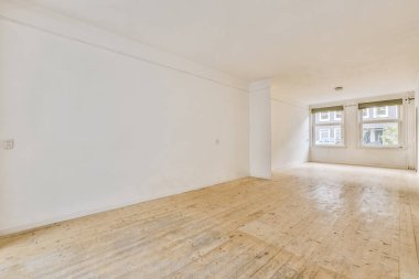 Ahşap zeminli, ferah, boş bir oda.