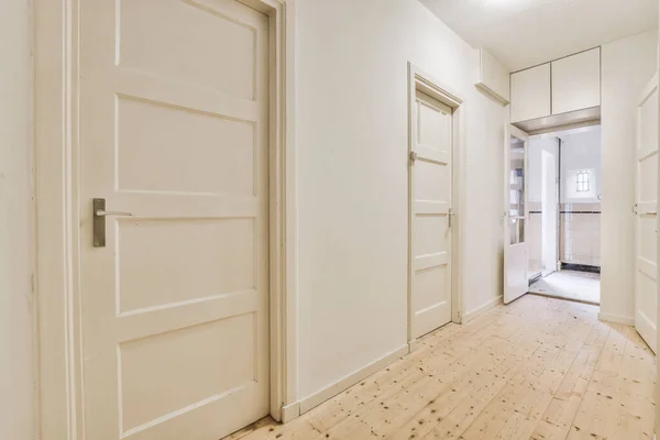 Geräumiger, gerader Korridor mit mehreren Türen — Stockfoto