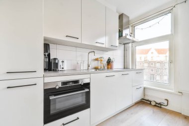 Beyaz mobilyalı modern mutfağın içi.