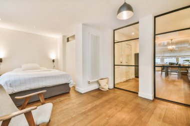 Geniş, parlak bir yatak odası ve büyük beyaz bir yatak odası.