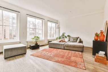 Ahşap zemini olan geniş, parlak bir oturma odası.