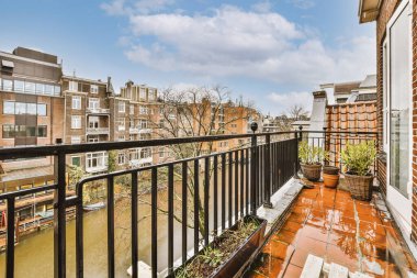 Metal çitli ve kanal manzaralı rahat bir balkon.