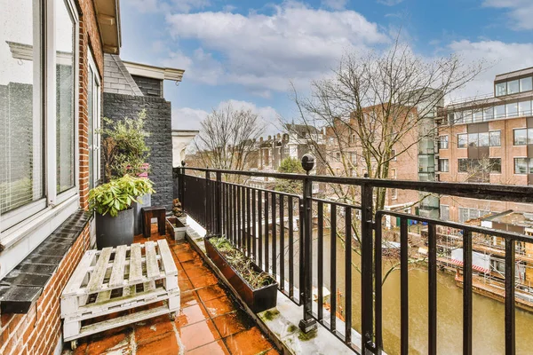 Metal çitli ve kanal manzaralı rahat bir balkon.