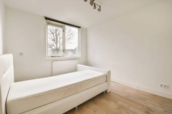 Bed en nachtkastje bij het raam — Stockfoto