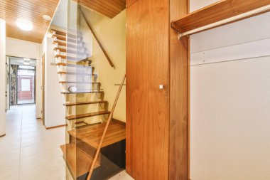 Geniş apartman koridorundaki ahşap merdiven.