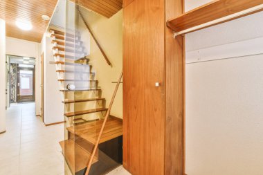 Geniş apartman koridorundaki ahşap merdiven.