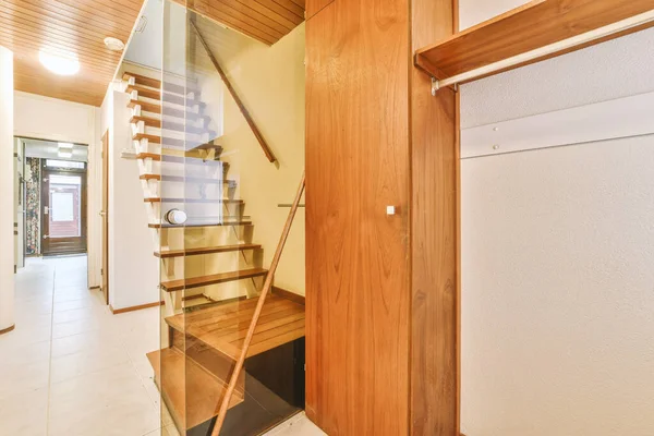 Geniş apartman koridorundaki ahşap merdiven.