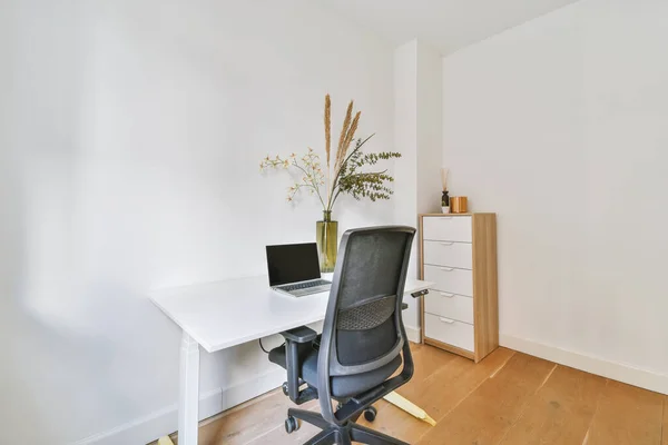 A bright white work area with a small laptop