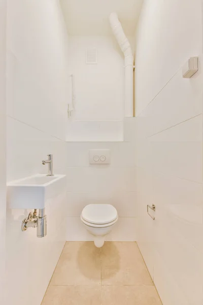 Простой туалет с небольшой раковиной — стоковое фото
