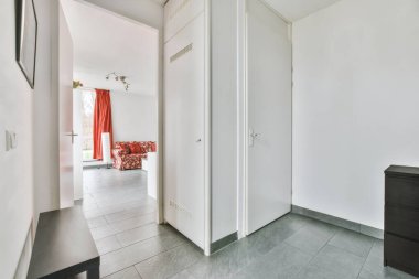 Beyaz duvarları ve parke zemini olan modern dairenin kapısı.