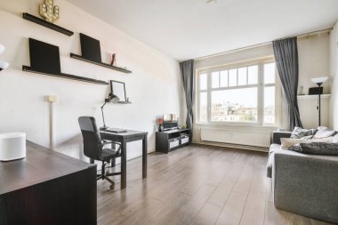 Masası ve rafları olan geniş çalışma odası.