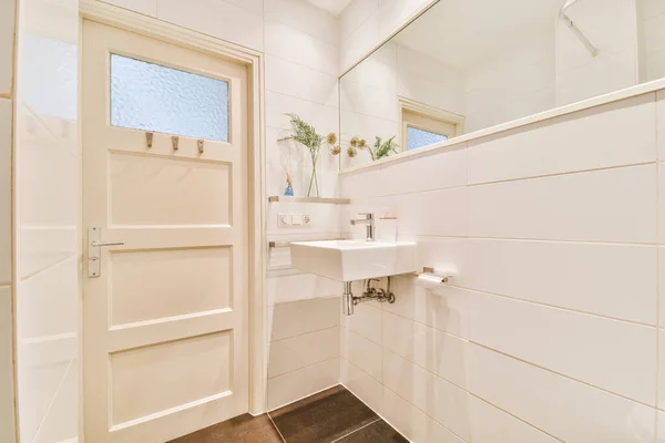 Fregadero y espejo cerca de la puerta del baño — Foto de Stock