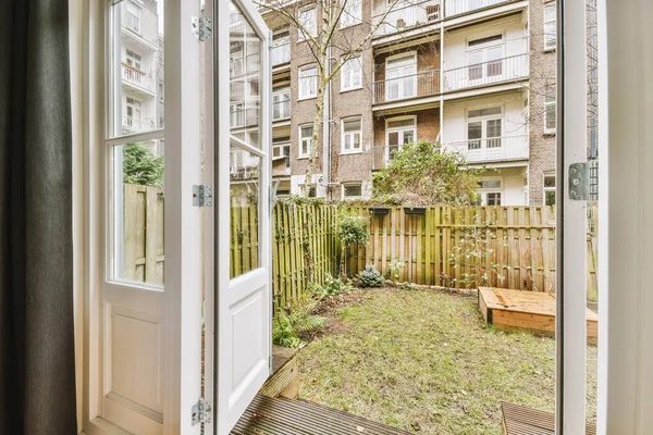 Çimenlerle ve ahşap çitlerle kaplı küçük bir bahçe.