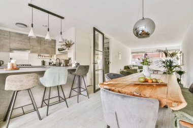 Oturma odasında kolye lambası olan bir yemek salonu.