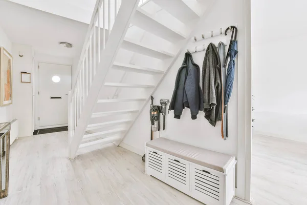 Деревянная лестница в просторном холле квартиры — стоковое фото