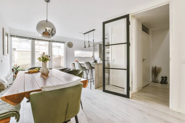 Oturma odasında kolye lambası olan bir yemek salonu.