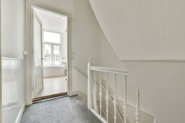 Geniş apartman koridorundaki ahşap merdiven.