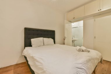 Ahşap gardıroplu aydınlık yatak odası.