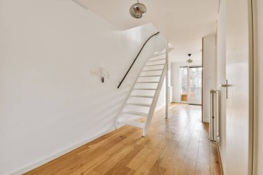 Geniş apartman koridorundaki ahşap merdiven.