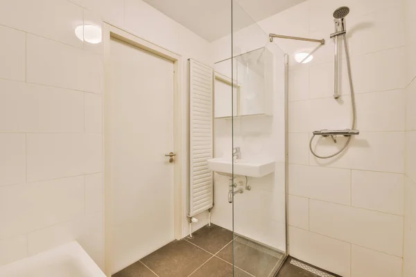 Lavandini e vasca da bagno vicino cabina doccia — Foto Stock