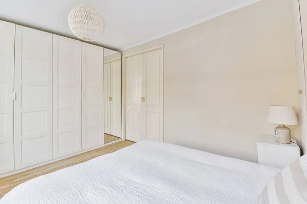 Светлая спальня с деревянным шкафом — стоковое фото