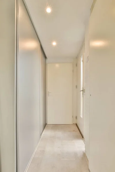 Узкий коридор с дверями и лампами — стоковое фото