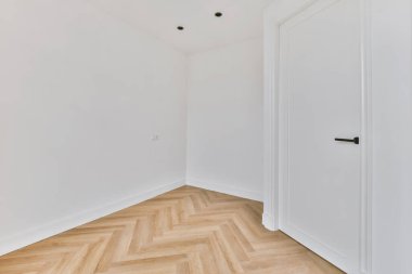 Kapısı olan beyaz boş odanın köşesi.